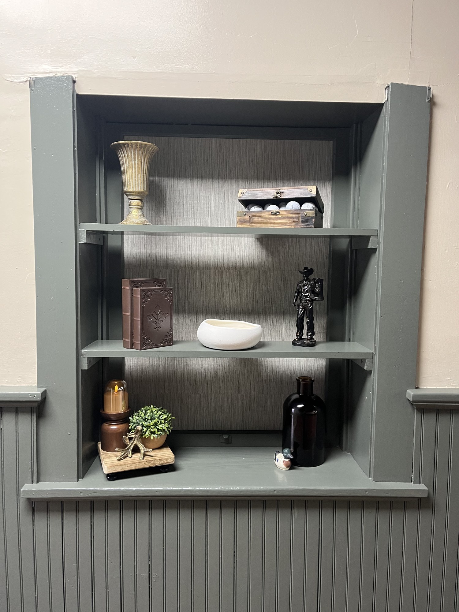 Vintage trophies and golf decor on a built-in shelf at Sim Village