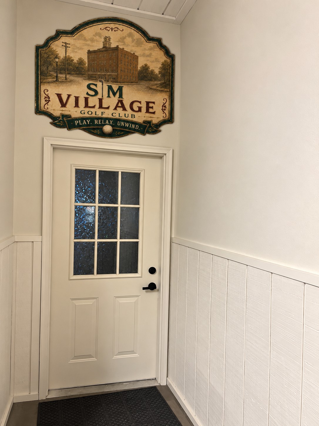 Sim Village entrance door with the club's shield sign above it