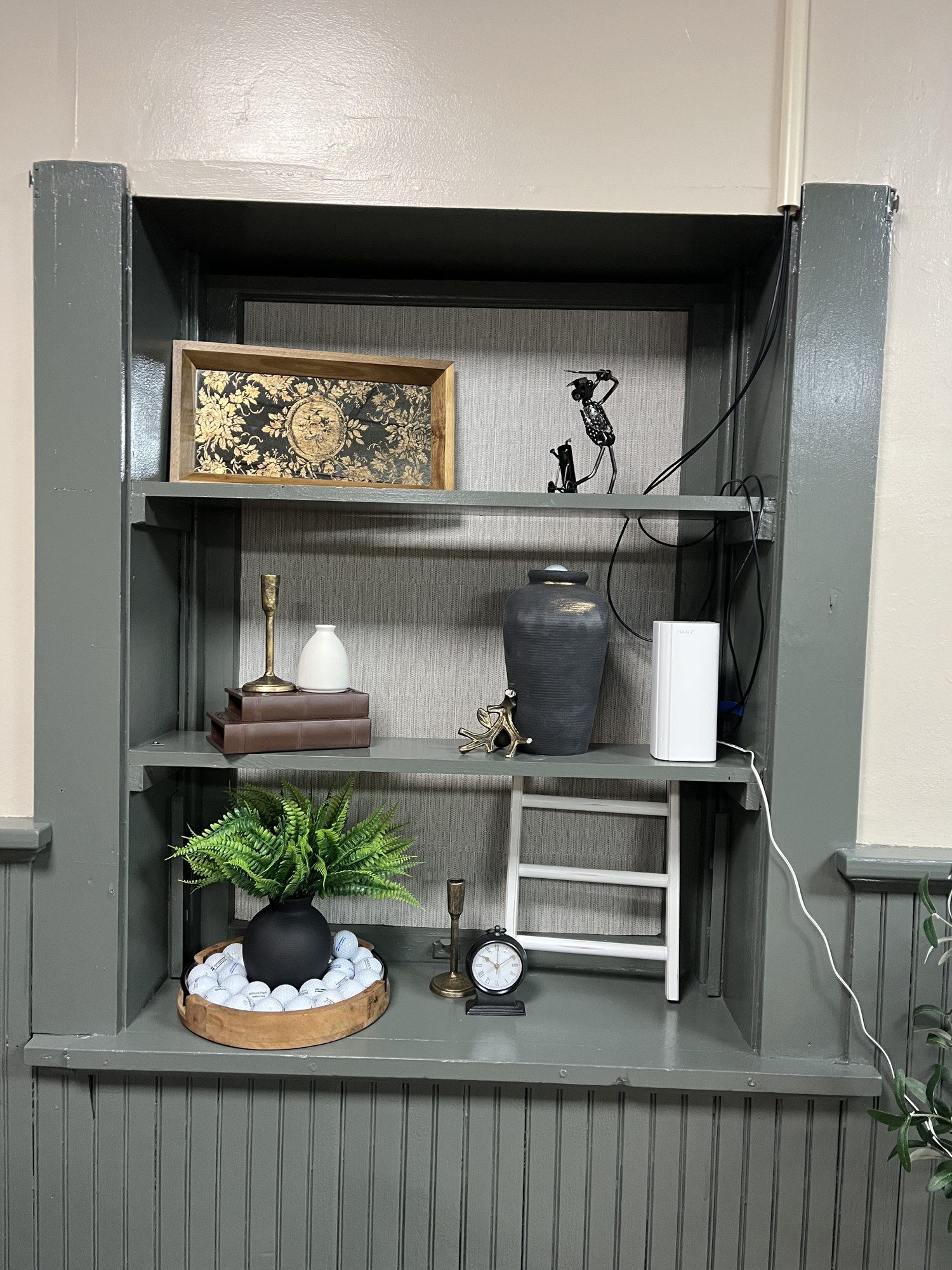 Built-in display shelf with vintage decor and plants at Sim Village